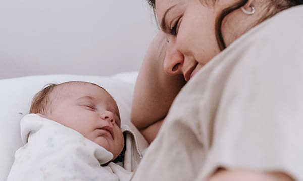newborn baby and mom on bed