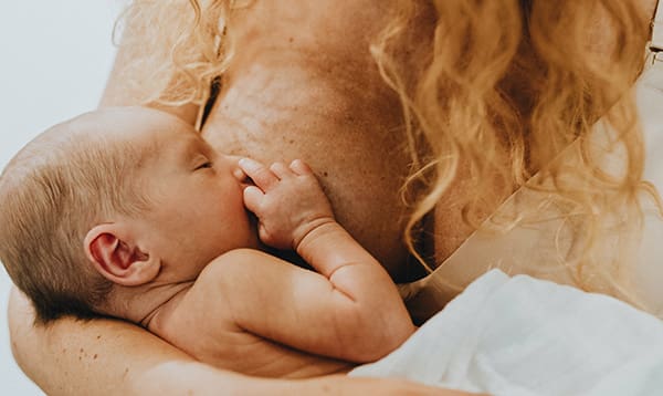 red-haired woman with inverted nipples breastfeeding her baby