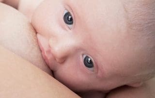 woman breastfeeding baby while milk supply is dropping