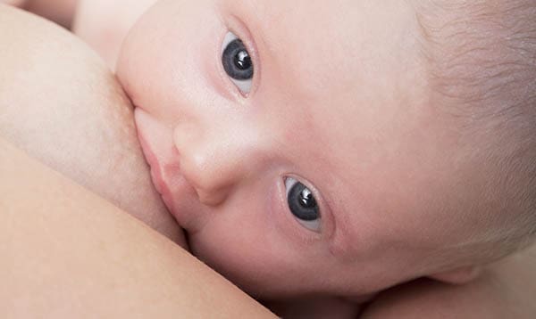 woman breastfeeding baby while milk supply is dropping