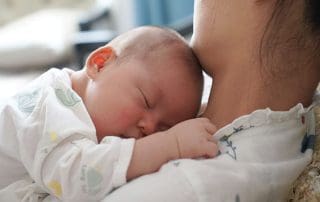 mother with baby trying to decide the best baby bottle